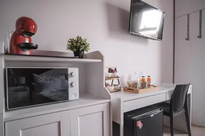 a small kitchen with a microwave and a table at B&B Vatican Stories in Rome
