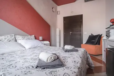 a bedroom with a large bed with a red wall at B&B Vatican Stories in Rome