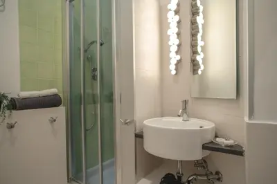 a white bathroom with a sink and a shower at B&B Vatican Stories in Rome