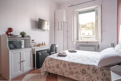 a small bedroom with a bed and a kitchen at B&B Vatican Stories in Rome