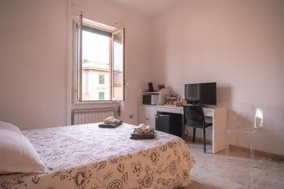 a bedroom with a bed and a desk and a window at B&B Vatican Stories in Rome