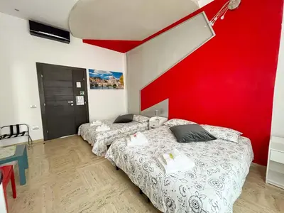 two beds in a room with a red wall at B&B Vatican Stories in Rome