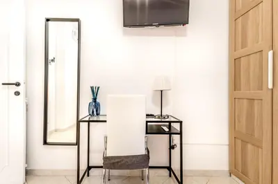 a mirror and a table and a chair in a room at Petite Maison 19 in Rome