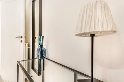 a glass table with a lamp and a mirror at Petite Maison 19 in Rome