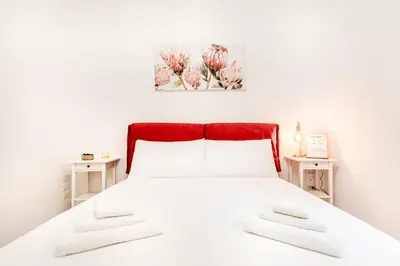 a bedroom with a white bed with two tables at Petite Maison 19 in Rome