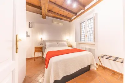 a white bedroom with a bed and a window at AC21 - Palazzetto Campo de' Fiori in Rome