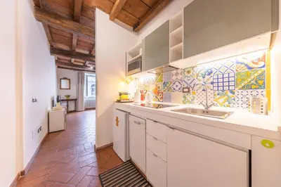 a kitchen with a sink and a tile wall at AC21 - Palazzetto Campo de' Fiori in Rome