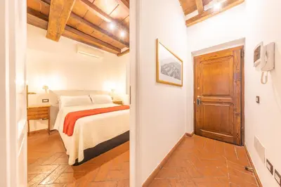 a bedroom with a bed and a wooden door at AC21 - Palazzetto Campo de' Fiori in Rome