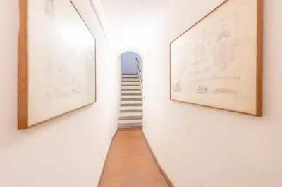 a hallway with two framed art and a stairway at AC21 - Palazzetto Campo de' Fiori in Rome