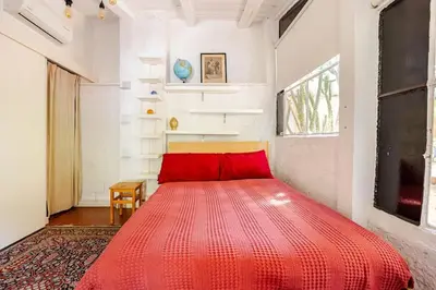 a red bed in a white room with a red blanket at Riad Riari in Rome