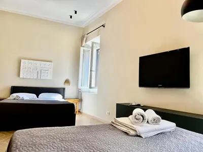 a bedroom with two beds and a flat screen tv at Trastevere Suite apartment in Rome