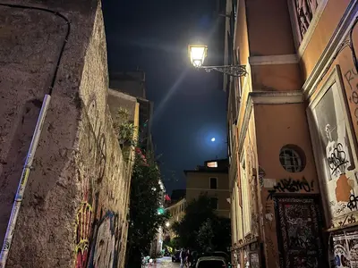 a street at night with a street light between two buildings at Trastevere Suite apartment in Rome