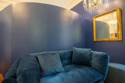 a table and chairs in a room with a blue wall at PgrHome Colosseo 11 BLU in Rome