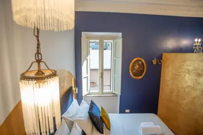 a living room with a white table and a blue wall at PgrHome Colosseo 11 BLU in Rome