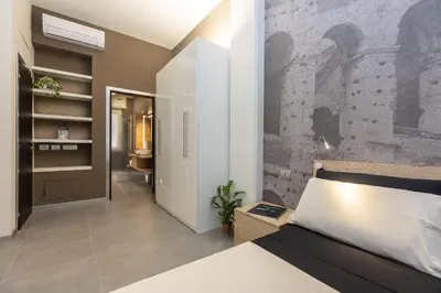 a bedroom with a bed and a brick wall at San Pietro Guest House in Rome