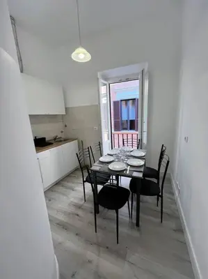 a dining room with a table and chairs and a kitchen at Campo de’ Fiori Rooftop Apartment in Rome