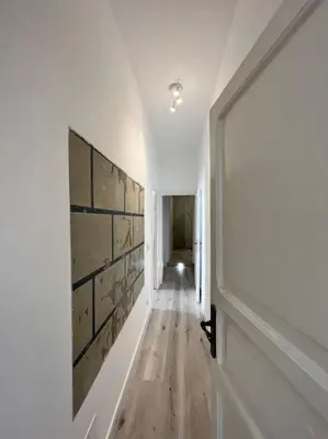 a hallway with white walls and a wooden floor at Campo de’ Fiori Rooftop Apartment in Rome