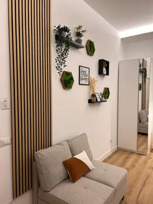 a living room with a couch and some plants on the wall at SIRI VATICAN LOFT - Design House Rome in Rome