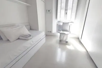 a white room with a bed and a window at Piazza di Spagna Home - Family Apartment in Rome