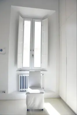 a white chair in a white room with a window at Piazza di Spagna Home - Family Apartment in Rome