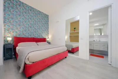 a bedroom with a red bed and a bathroom at Porta San Giovanni Suite in Rome