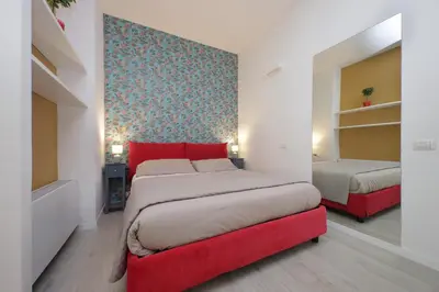 a bedroom with two beds and a red headboard at Porta San Giovanni Suite in Rome