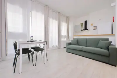 a living room with a green couch and a table at Porta San Giovanni Suite in Rome