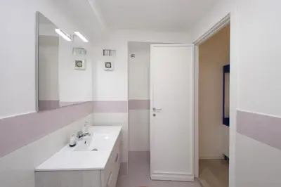 a white bathroom with a sink and a mirror at Porta San Giovanni Suite in Rome