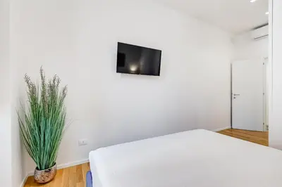 a bedroom with a white bed and a tv on the wall at Opera Exclusive House by Premium Suites Collection in Rome