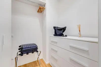 a room with white drawers and a black suitcase on a stool at Opera Exclusive House by Premium Suites Collection in Rome