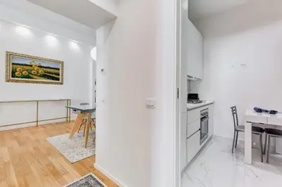 a kitchen with white walls and a dining room with a table at Opera Exclusive House by Premium Suites Collection in Rome