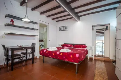 a bedroom with a red bed and a table at Apartment Gaia in Rome
