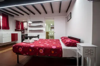 a bedroom with a bed with red sheets and red pillows at Apartment Gaia in Rome