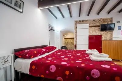 a bedroom with a large red bed with towels on it at Apartment Gaia in Rome