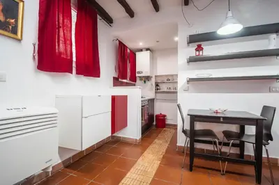 a kitchen with a table and chairs and red curtains at Apartment Gaia in Rome