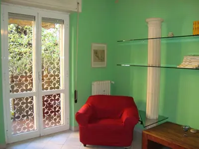 a living room with a red chair and a window at La Casa Dei Gerani in Rome