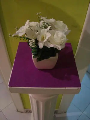 a vase of flowers sitting on a purple table at La Casa Dei Gerani in Rome