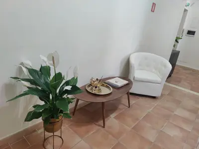 a living room with a table and a chair and a plant at Holiday 168 Guest House in Rome