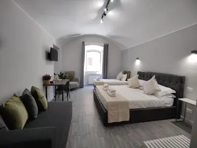 a bedroom with a large bed and a couch at Holiday 168 Guest House in Rome