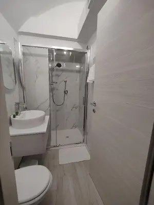 a bathroom with a shower and a toilet and a sink at Holiday 168 Guest House in Rome