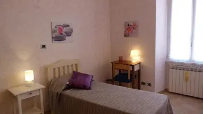 a bedroom with a bed with a purple pillow at Rossanella House in Rome