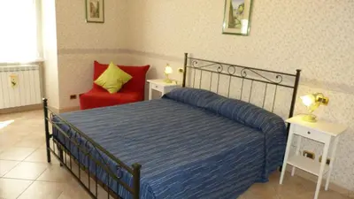 a bedroom with a bed and a red chair at Rossanella House in Rome