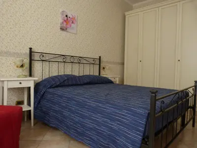 a bedroom with a bed with a blue striped blanket at Rossanella House in Rome