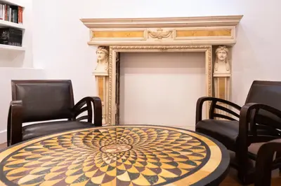 a table and chairs in a room with a fireplace at Charme & Chic San Giacomo in Rome
