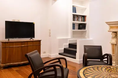 a living room with a tv and a table and chairs at Charme & Chic San Giacomo in Rome