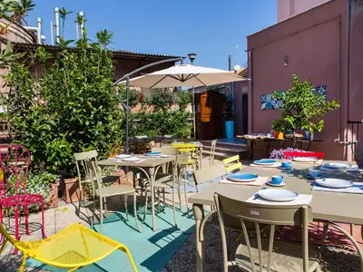 a patio with tables and chairs and an umbrella at Salotto Monti in Rome
