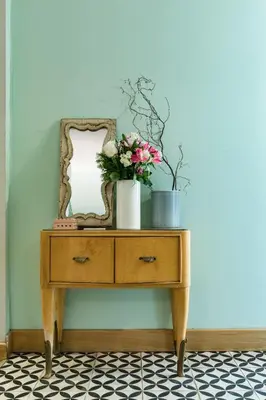 a dressing table with a mirror and flowers on it at Salotto Monti in Rome