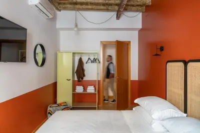 a man walking into a room with two beds at Salotto Monti in Rome