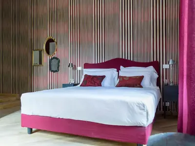 a bedroom with a large bed with white sheets and red pillows at Salotto Monti in Rome