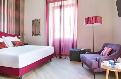 a bedroom with a bed and a chair at Salotto Monti in Rome